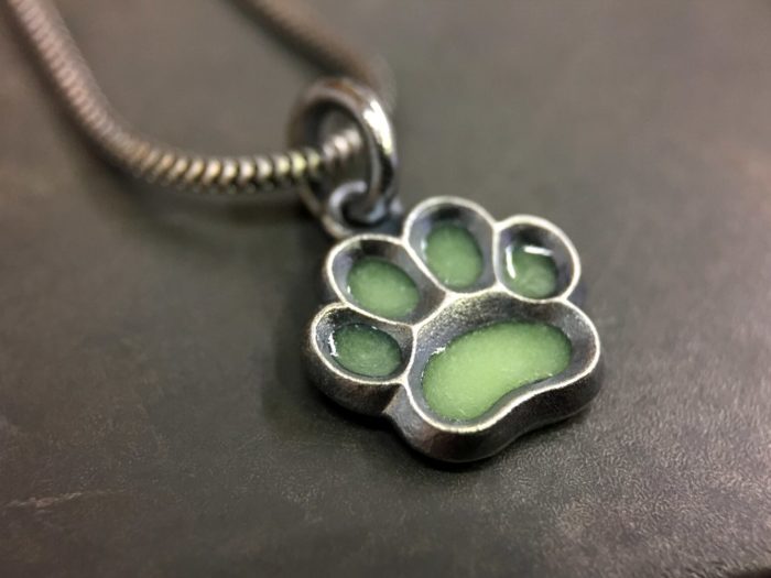 ujo_rocks_paw_pendant_sterling_silver_green_glow_in_the_dark_frosted_oxidised_daytime_front