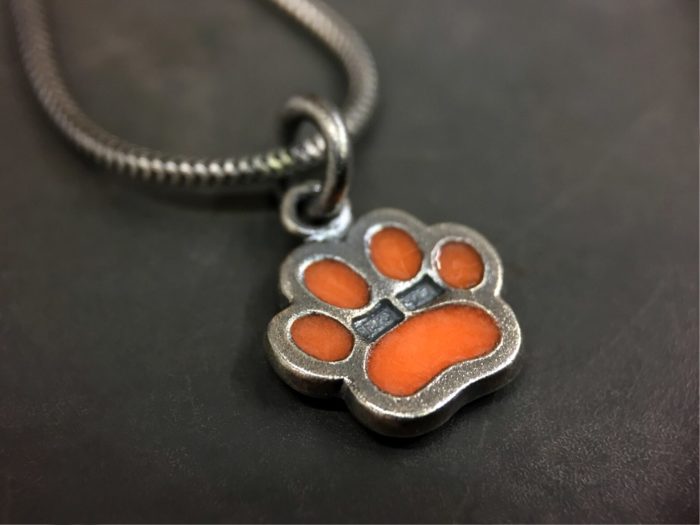 ujo_rocks_paw_pendant_sterling_silver_orange_glow_in_the_dark_frosted_oxidised_daytime_back