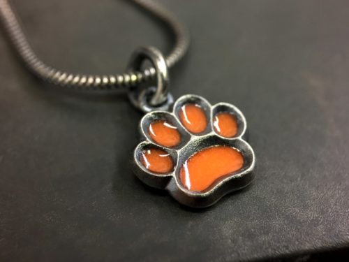 ujo_rocks_paw_pendant_sterling_silver_orange_glow_in_the_dark_frosted_oxidised_daytime_front